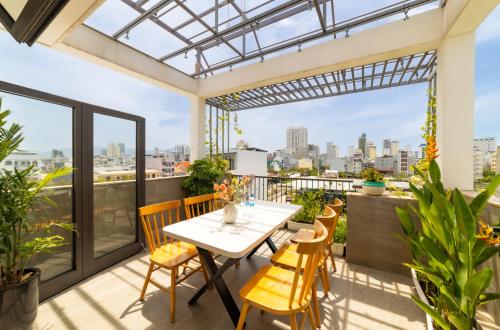 einen Balkon mit einem Tisch und Stühlen sowie Stadtblick in der Unterkunft Sóng homestay 4 - The spacious house - In the Prime location in Đà Nẵng