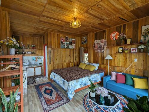 Un dormitorio con una cama y un sofá azul. en Đồi Gió Homestay & Campsite, en Ha Giang