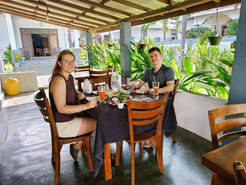 Un hombre y una mujer sentados en una mesa en un restaurante. en Negombo Signature Villa, en Negombo