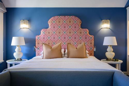 a bedroom with a large bed with a pink headboard at Yallungah Boutique Hotel in Orange