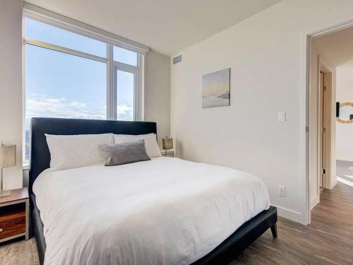een slaapkamer met een groot bed met een groot raam bij Corporate Stays Hazel 1 Bedroom in Burnaby