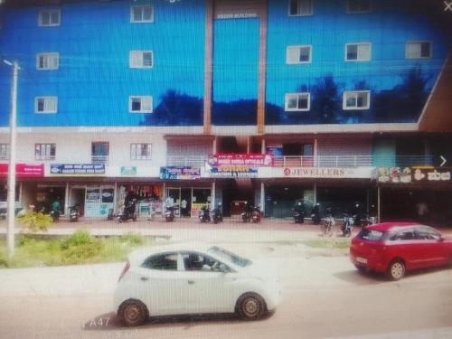 two cars parked in a parking lot in front of a building at Sohan Boarding and Lodging in Perdūru