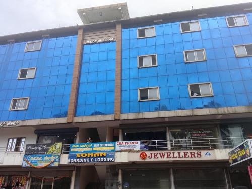 a blue building with windows on a city street at Sohan Boarding and Lodging in Perdūru