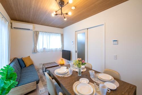 a dining room with a table and a couch at RENVI Ukiha ー福岡の宿ー in Ukiha