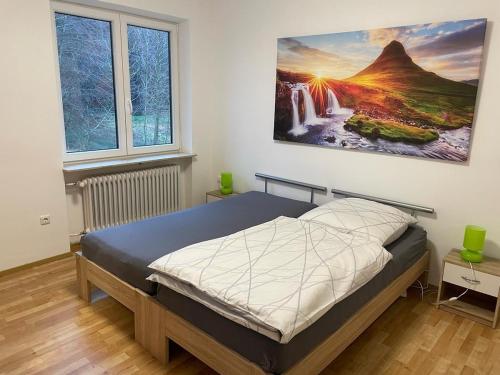 a bedroom with a bed with a painting on the wall at Ferienhaus Heiligenmühle in Leinburg