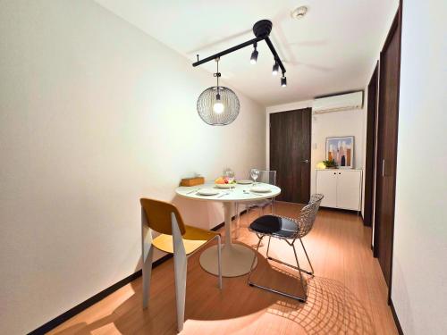 a dining room with a white table and chairs at Healing Inn Osaka Fukushima in Osaka
