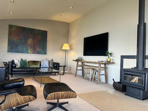 a living room with a couch and a fire place at Alpine Luxury on London in Queenstown