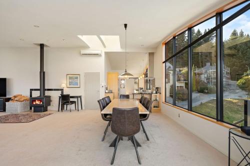 a dining room with a table and chairs and a fireplace at Alpine Luxury on London in Queenstown