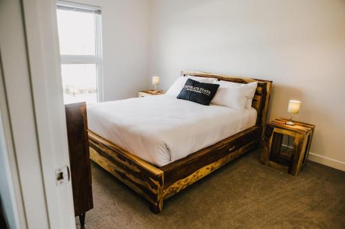 ein Schlafzimmer mit einem Bett mit weißen Laken und einem Fenster in der Unterkunft The Spot - Fully Furnished 2 Bedrooms Apartment in Winnipeg in Tuxedo