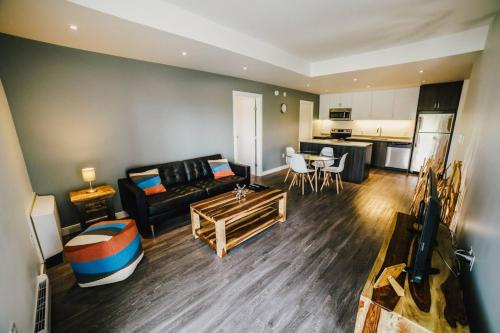ein Wohnzimmer mit Sofa und Tisch in der Unterkunft The Spot - Fully Furnished 2 Bedrooms Apartment in Winnipeg in Tuxedo