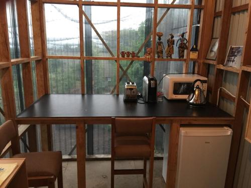 a kitchen with a table with a microwave and a window at Absolute waterfront with a secret garden in Carlton