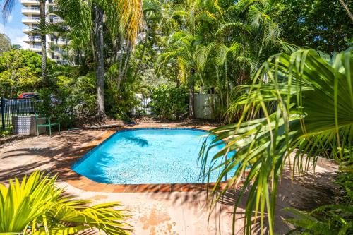 a swimming pool in a yard with palm trees at Seaside Apartments Broadbeach in Gold Coast