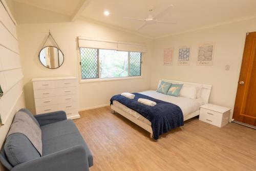 een slaapkamer met een bed, een bank en een spiegel bij Sandcastles 2 in Point Lookout