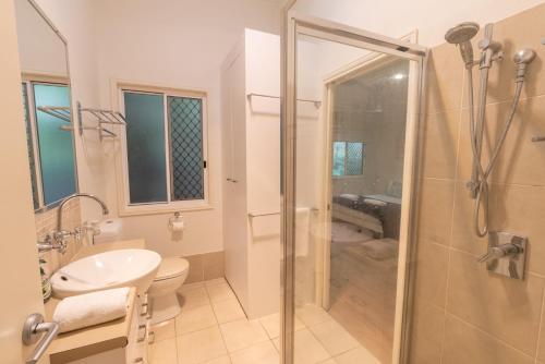 een badkamer met een douche, een toilet en een wastafel bij Sandcastles 2 in Point Lookout