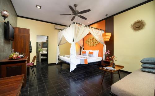 a bedroom with a bed with a ceiling fan at Residence Indochine Suite in Siem Reap