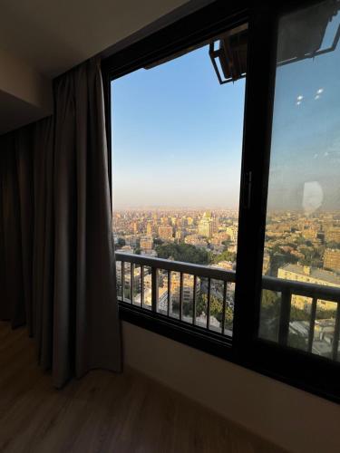 a room with a large window with a city view at Lumen Residence in Cairo