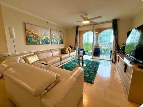 a living room with a couch and a flat screen tv at The Costal, stunning water view apartment at Aventura Yacht Club, Miami Florida! in Sun Swept Isles