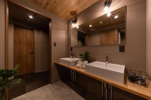 a bathroom with two sinks and a mirror at おやど紀伊国屋宝町 in Nagasaki