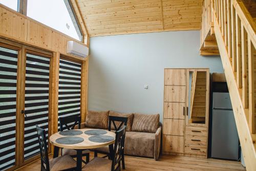 HuwnikiにあるDomki nad Wiarem 2のテーブルと椅子とソファのある部屋