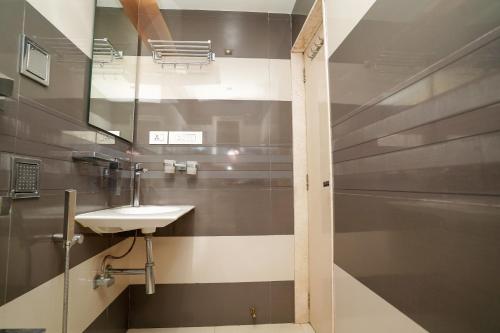 a bathroom with a sink and a mirror at UrbanNest Service Apartments Powai in Mumbai