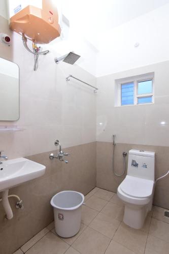 a bathroom with a toilet and a sink at Pondicherry Comfort Rooms in Puducherry