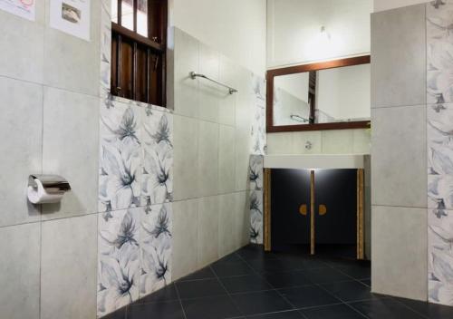 a bathroom with a hallway with a mirror and a door at Osara Holiday Home in Anuradhapura