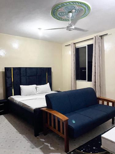 a bedroom with a bed and a couch at Mombasa Town CBD Studio in Mombasa