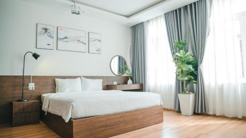 a bedroom with a large bed and a large window at Son Tra homestay in Danang