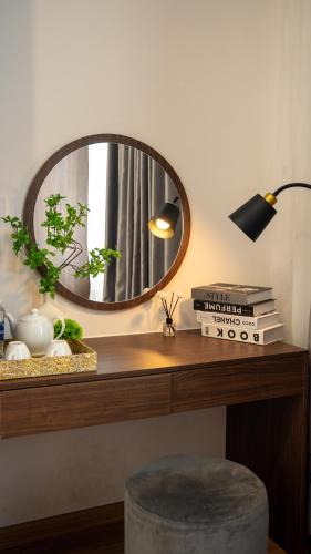 a mirror on a desk with books and a lamp at Son Tra homestay in Danang