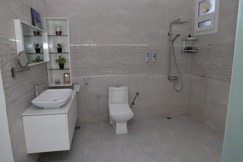 a bathroom with a toilet and a sink and a shower at شالية ماربيا الاشخرة Marbella Ashkhara Chalet in Al Ashkharah