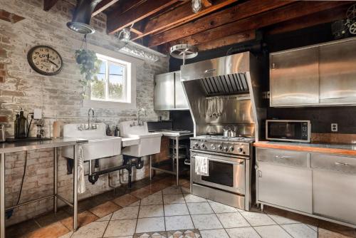 a large kitchen with two sinks and a stove at Unique 2-BDR Historic Warehouse Loft with Terrace ! ! ! in Windsor