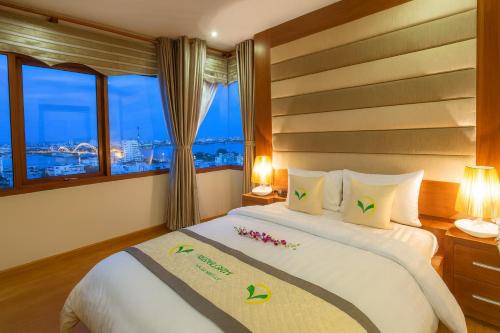a bedroom with a bed with a view of the city at Moonlight Hotel & Apartment in Da Nang