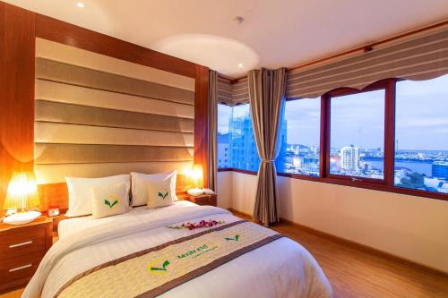 a bedroom with a bed with a large window at Moonlight Hotel & Apartment in Da Nang