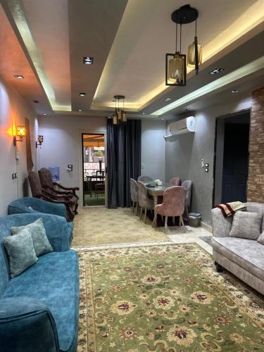 ein Wohnzimmer mit blauen Sofas und einem Tisch in der Unterkunft Gardinia City luxury Home with 3bed rooms and private pool in Kairo