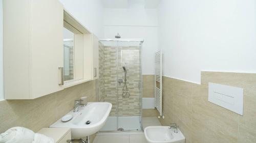 un bagno bianco con lavandino e doccia di La vista dal borgo a Toscolano Maderno