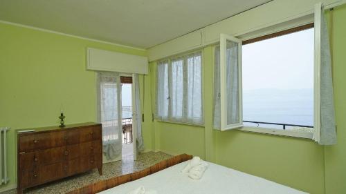 una camera da letto con un letto e una finestra con vista di La vista dal borgo a Toscolano Maderno