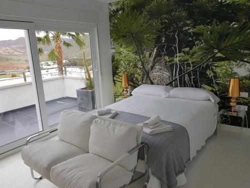 a bedroom with a bed and a chair and a window at Villa de Luxe in San José