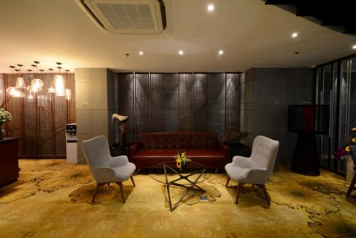 a living room with a couch and two chairs at The Chi Boutique Hotel in Hanoi