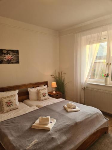 a bedroom with a large bed with towels on it at Idylle am See in Zossen