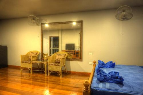 a bedroom with a bed and a table and a mirror at Gila's Garden in Lamai