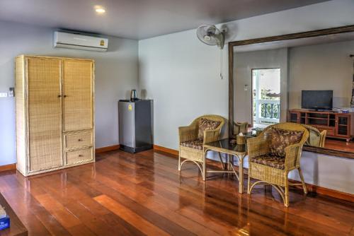 a living room with a table and chairs and a refrigerator at Gila's Garden in Lamai