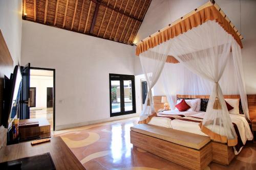 a bedroom with a bed with a mosquito net at Villa Seminyak Estate & Spa - By Astadala in Seminyak