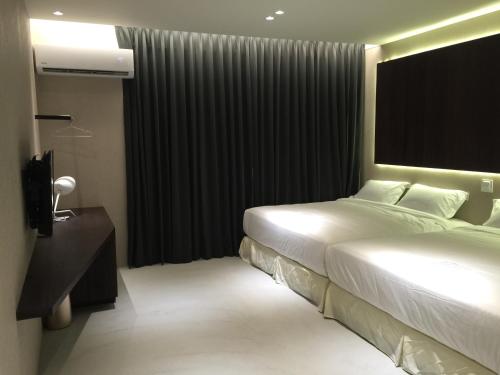 um quarto de hotel com uma cama e uma grande janela em Kenting Feliz Hotel em Kenting