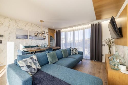 a living room with a blue couch and a table at D&S - Foz Riverside Apartment in Porto