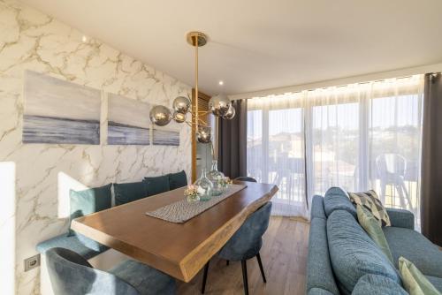 a dining room with a table and a blue couch at D&S - Foz Riverside Apartment in Porto