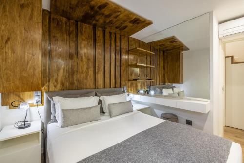 a bedroom with a white bed and wooden walls at D&S - Foz Riverside Apartment in Porto