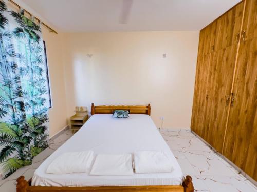 a bedroom with a bed and a large window at BUXTON POINT APARTMENTs in Mombasa