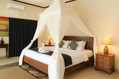 a bedroom with a bed with a canopy at The Kanjeng Signature Sidemen in Sidemen