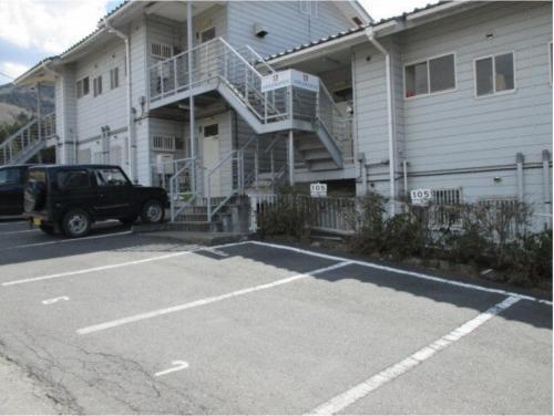 a car parked in a parking lot in front of a house at Chichibu Mizuno-stay 水野ステイ最大６名様 in Chichibu