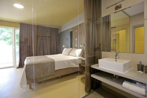 1 dormitorio con cama, lavabo y espejo en Kai Boutique Studio & Rooms, en Zadar